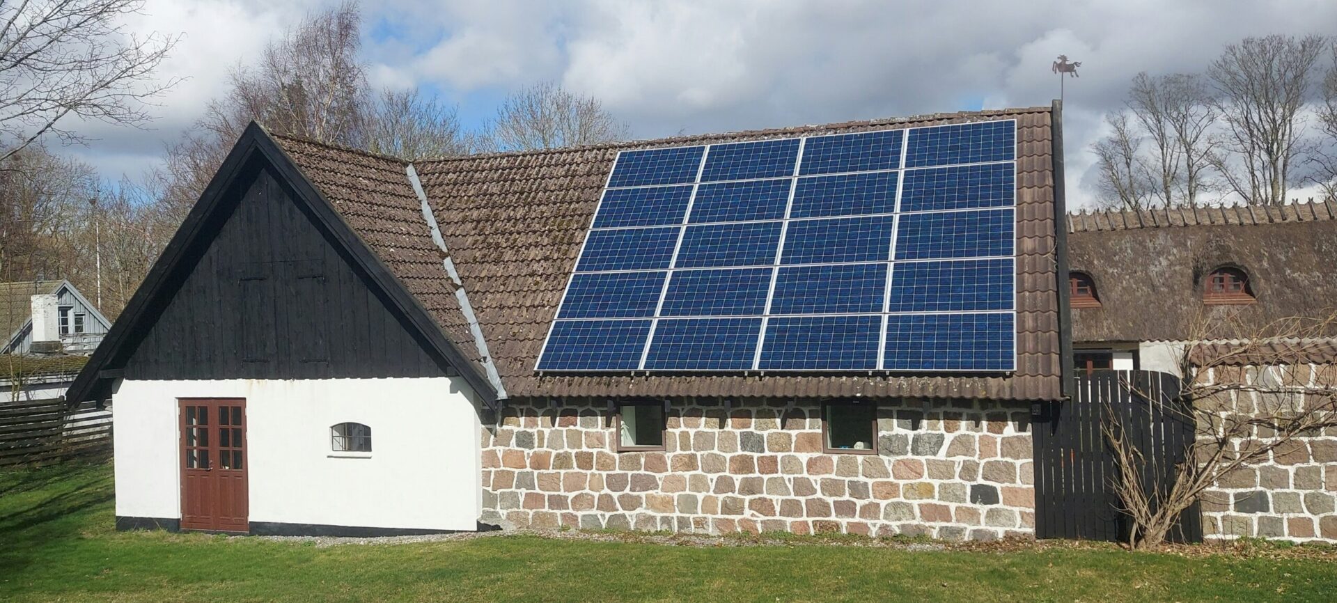 Modern house with rooftop solar panels under a clear sky, representing sustainable energy solutions by a commercial solar company in Minnesota.