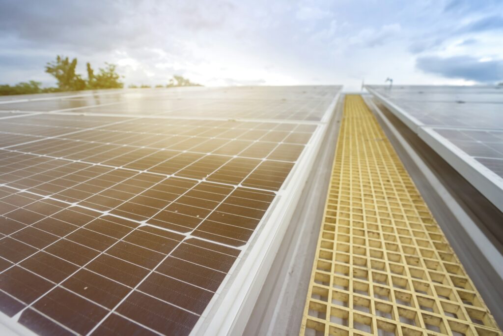 Home with rooftop solar panels and a battery storage unit, representing energy independence and cost savings with modern solar battery storage.