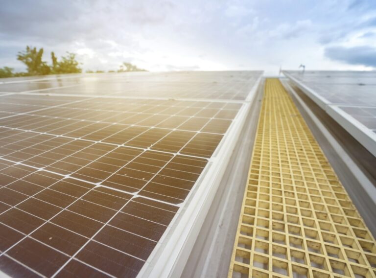 siwawut-phoophinyo-rylkLLumk9k-unsplash Home with rooftop solar panels and a battery storage unit, representing energy independence and cost savings with modern solar battery storage.